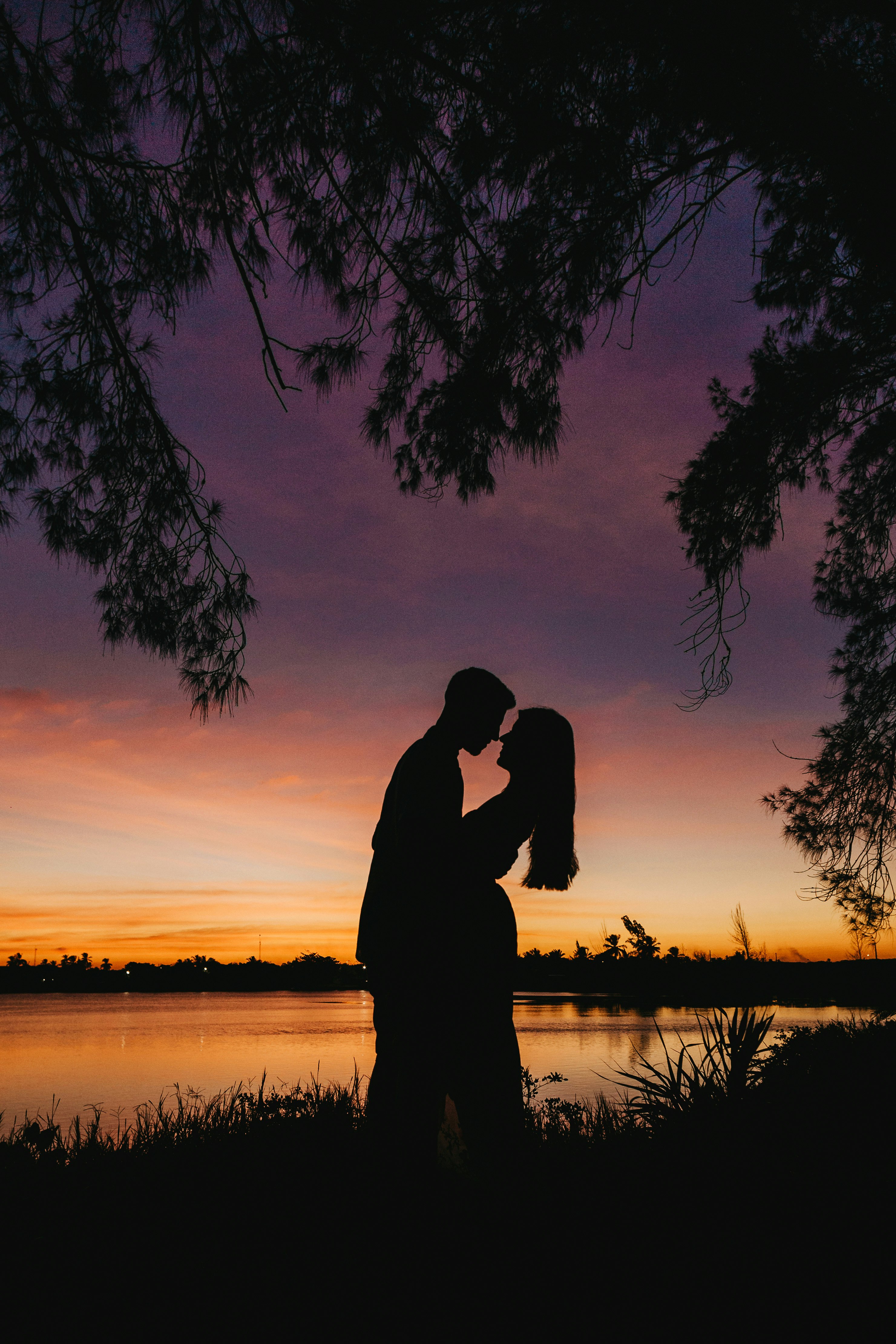 silhouette of man and woman kissing during sunset